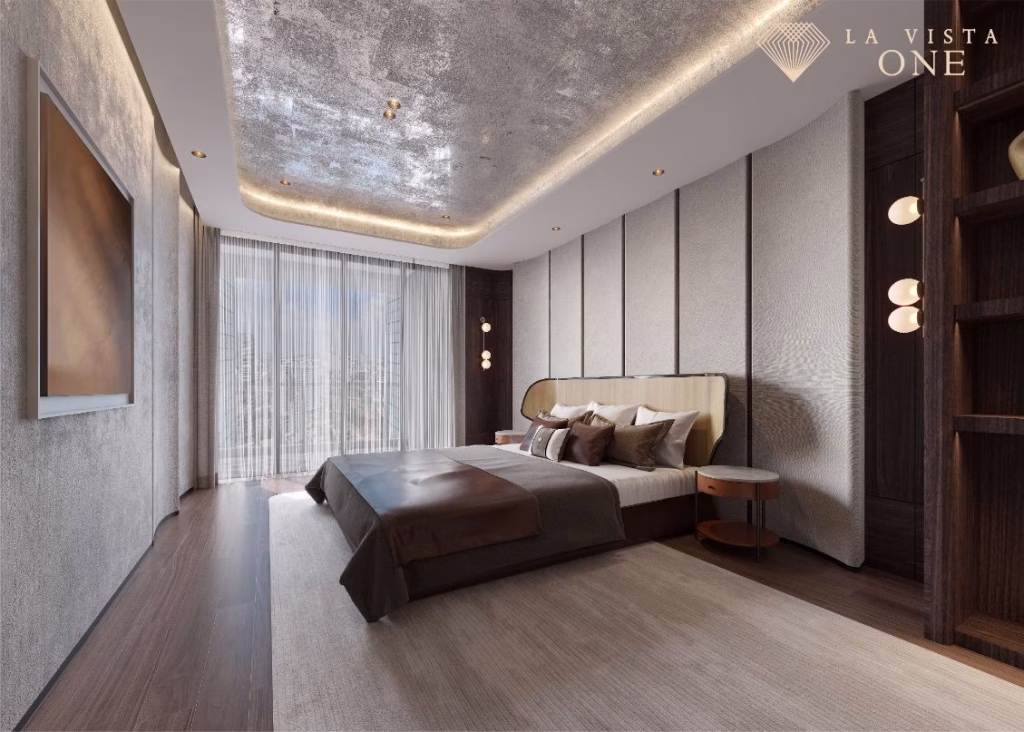 A modern, luxurious bedroom at La Vista One features a large bed, floor-to-ceiling windows, elegant lighting, textured walls, and wood accents. Bright natural light fills the space, highlighting neutral tones and contemporary decor. Logo appears top right.