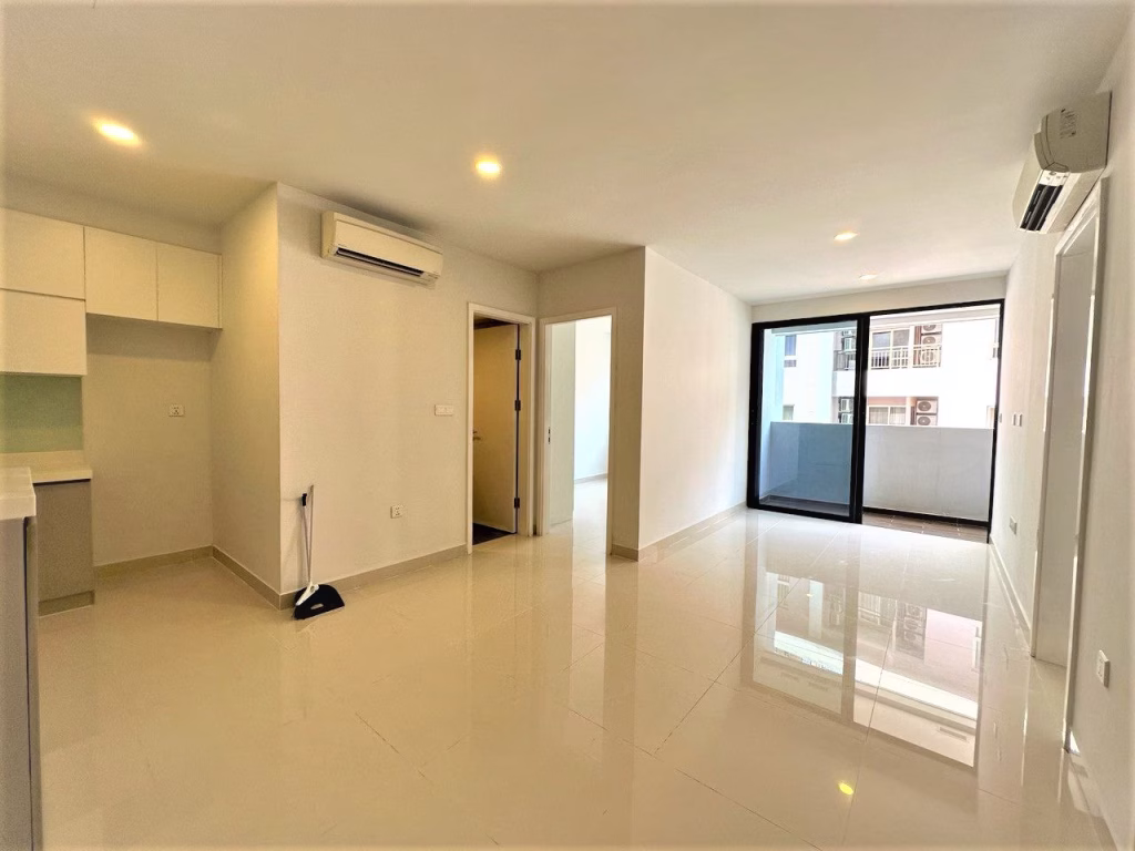 Modern, unfurnished 2 bedroom condo with tiled floors, white walls, built-in kitchen cabinets, two wall-mounted air conditioners, sliding glass doors to a balcony, and bright ceiling lights. A broom and dustpan are near the entrance.