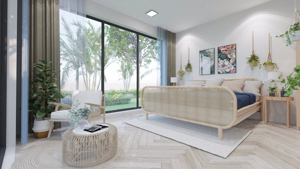 A bright, modern bedroom in one of the kampot homes for sale features large glass doors, light wood furniture, indoor plants, a white armchair, and botanical wall art—opening to a lush garden with trees and greenery outside.