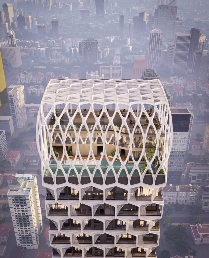 A modern high-rise building with a geometric lattice facade features an open rooftop area with a swimming pool, greenery, and lounge spaces, overlooking the bustling cityscape near Time Square 6 and its surrounding tall buildings.
