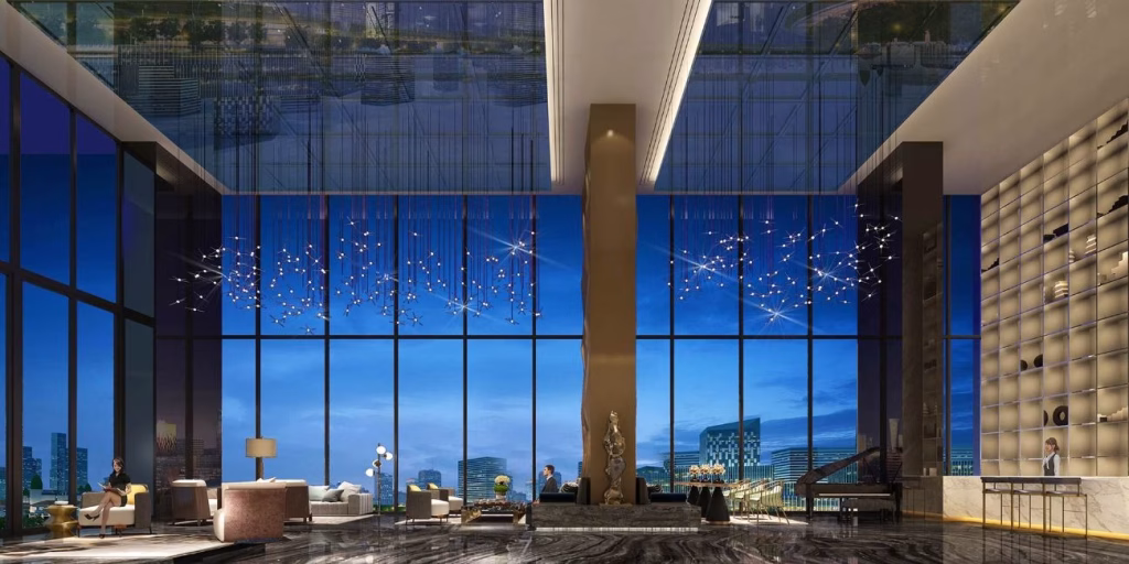 A luxurious riverfront hotel lobby with high ceilings, modern chandeliers, floor-to-ceiling windows revealing a city skyline at dusk, elegant seating areas, and a reception desk on the right.