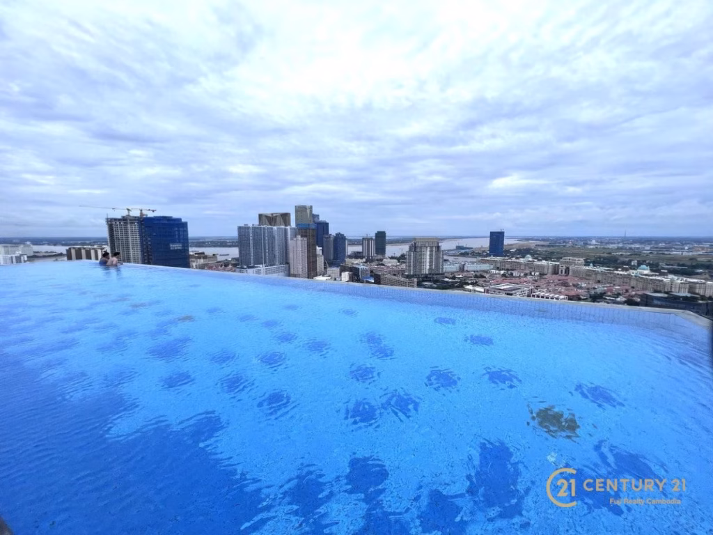 Experience the luxury of The Penthouse Residence with a stunning rooftop infinity pool overlooking the city skyline, where tall buildings meet a partly cloudy sky. Century 21 Realty logo displayed in the bottom right corner.